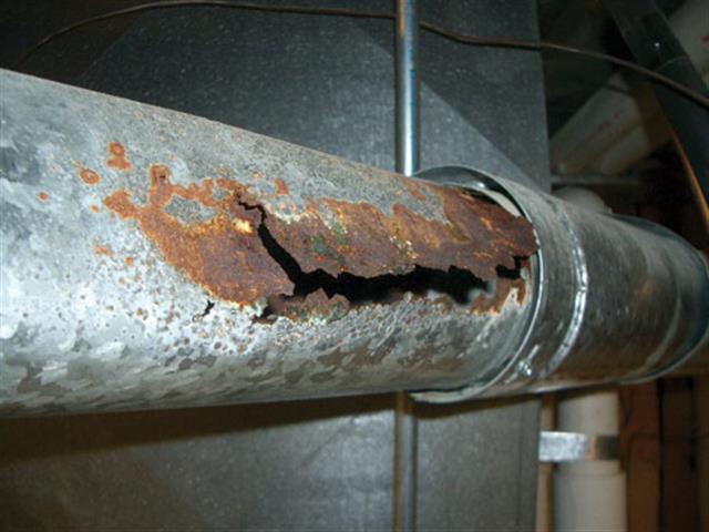 rust hole slit through furnace flue pipe allows carbon monoxide into living quarters